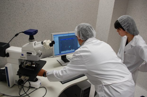 The research team in front of the microscope